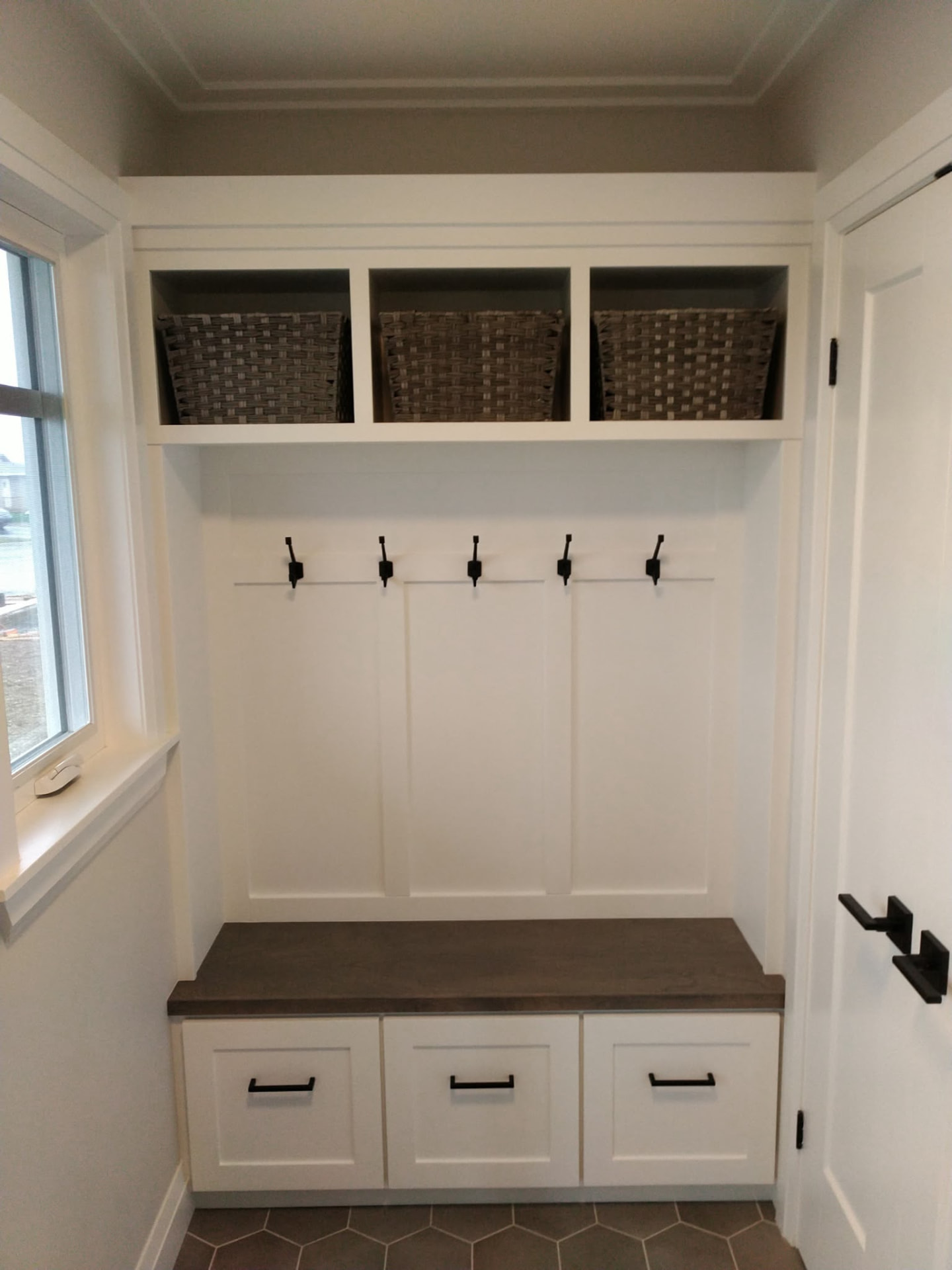 Custom white mudroom built-in with bench and storage